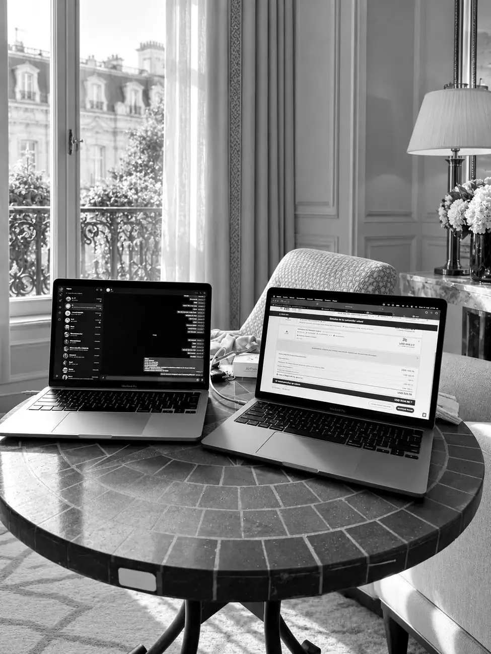Desk with two laptops in front of a window in Paris